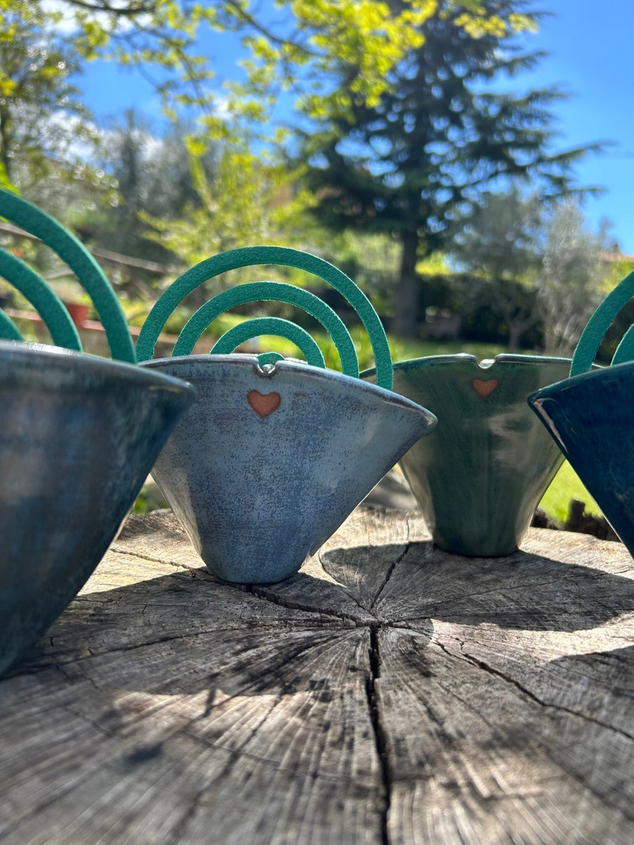 Gli stessi pezzi sul ceppo, controluce, con il giardino alle spalle.