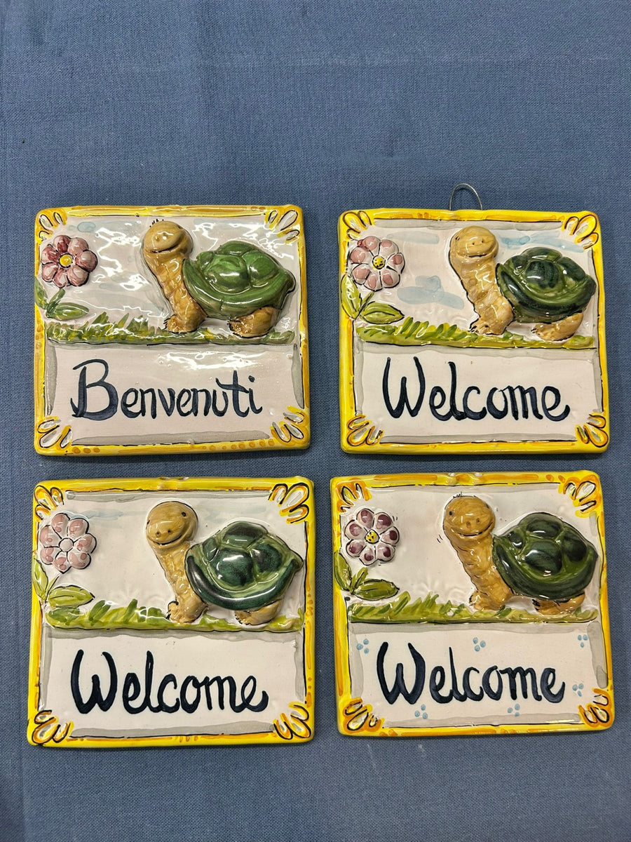 Quattro pezzi uguali affiancati, con le scritte «Benvenuti» e «Welcome».