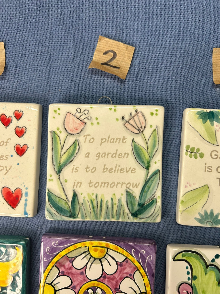 La mattonella con i tulipani e la frase «To plant a garden is to believe in tomorrow».