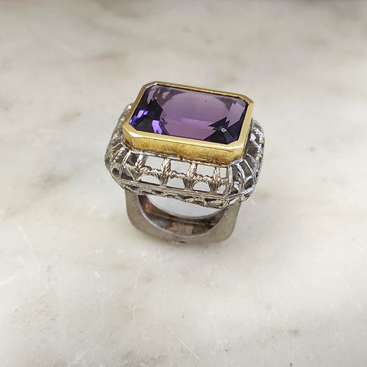 L'anello di tre quarti su marmo: l'ametista nel castone d'oro giallo sopra la cassa d'argento traforata