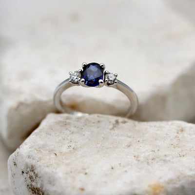 L'anello di fronte su una pietra chiara: lo zaffiro ovale al centro fra i due brillanti
