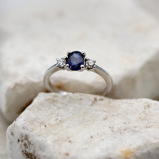 L'anello di fronte su una pietra chiara: lo zaffiro ovale al centro fra i due brillanti
