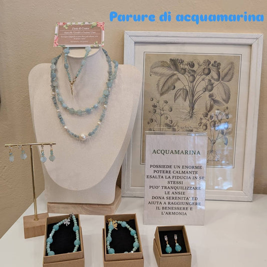 Parure di acquamarina: due collane su busto, orecchini, bracciali nelle scatoline e il cartoncino sulla pietra