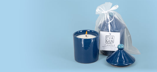 La candela blu mare accanto al sacchetto di organza con l'etichetta EVA MUN