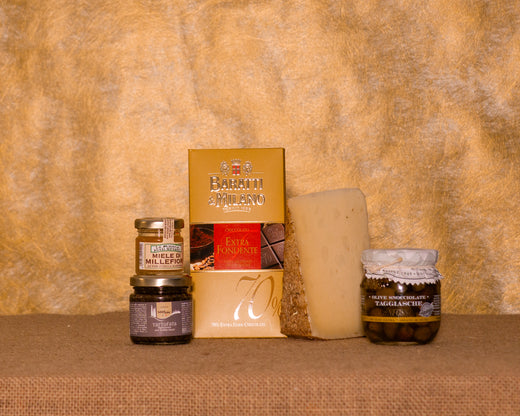 I 5 prodotti del cesto «Assaggio Gourmet» disposti sul fondo di juta, fra cui Salsa tartufata Naturbosco, Olive taggiasche Anfosso sott’olio evo e Pecorino Toscano “Il Paglione”, e gli altri.