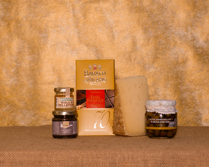 I 5 prodotti del cesto «Assaggio Gourmet» disposti sul fondo di juta, fra cui Salsa tartufata Naturbosco, Olive taggiasche Anfosso sott’olio evo e Pecorino Toscano “Il Paglione”, e gli altri.