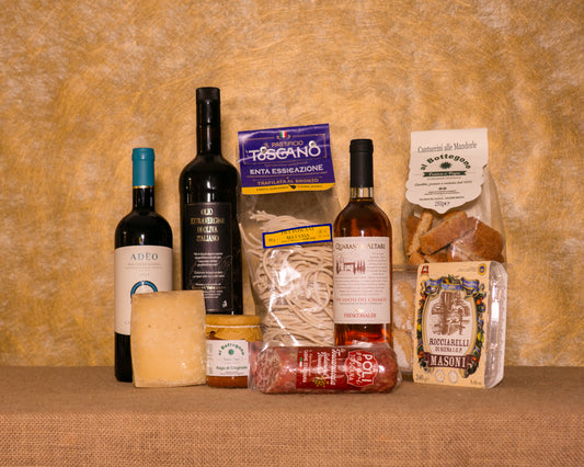 I 9 prodotti del cesto «Cuore Toscano» disposti sul fondo di juta, fra cui Pici Pastificio Toscano, Ragù di cinghiale e Adeo Bolgheri DOC, e gli altri.