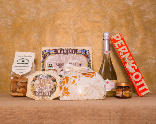 I 7 prodotti del cesto «Dolce Natale» disposti sul fondo di juta, fra cui Pandoro Tre Marie, Asti DOCG Rosa Regale Banfi e Ricciarelli di Siena IGP Masoni, e gli altri.