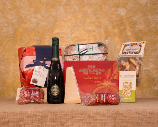 I 9 prodotti del cesto «Il Cuore del Natale» disposti sul fondo di juta, fra cui Panettone Fiasconaro, Valdobbiadene Superiore DOCG ExtraDry Bellussì e Cantuccini di Siena IGP Masoni, e gli altri.