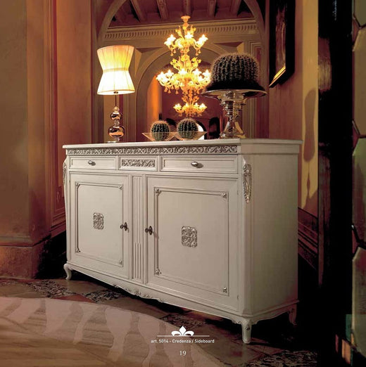 La pagina di catalogo della credenza 5014 in una sala: le due ante riquadrate, i cassetti sopra e le placche in argento