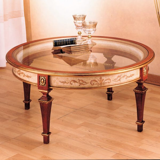 Il tavolino 2067 tondo con il piano in cristallo: la fascia dipinta e le quattro gambe rosse scanalate con i capitelli in oro
