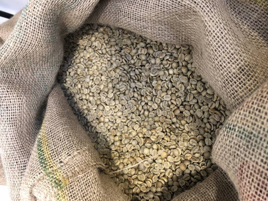I chicchi di caffe verde crudo nel sacco di juta