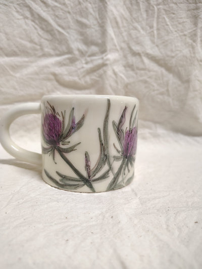 Tazza con due teste di cardo viola e le foglie spinose