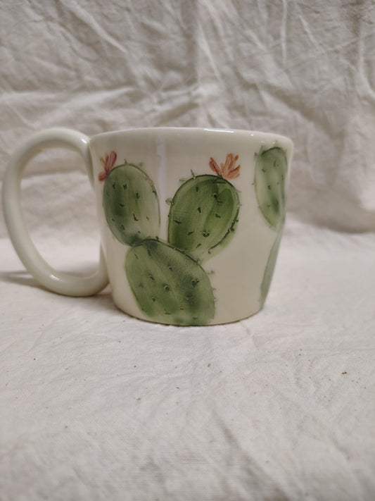 Tazza con le pale del fico d'India e i fiori aranciati
