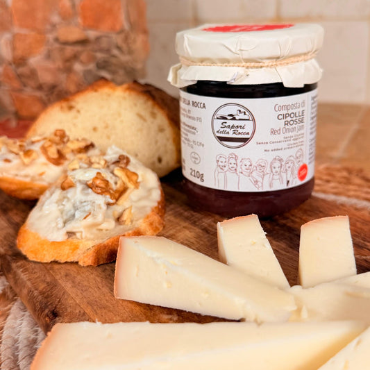 Crostini col formaggio e la composta sopra, con le fette di marzolino sul tagliere