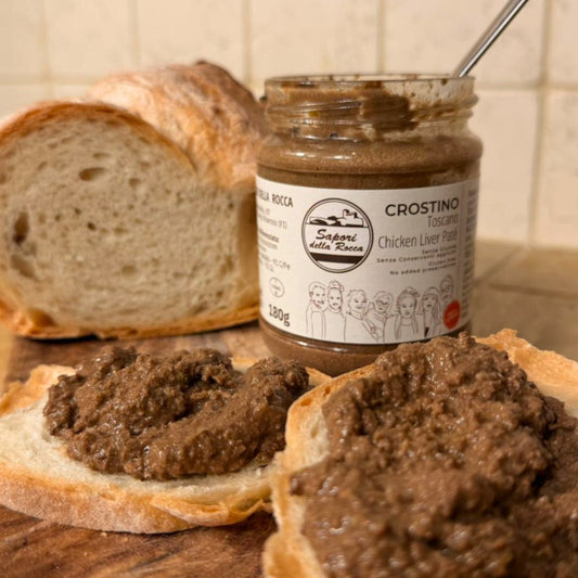 Il patè spalmato su due fette di pane, accanto al filone e al vasetto aperto