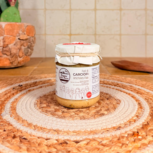 Il vasetto di Patè di carciofi con la fascetta di stoffa, sul centrino all'uncinetto