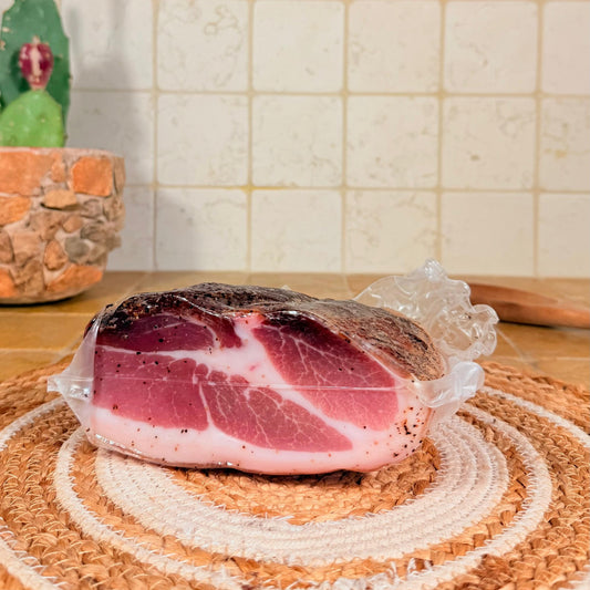Il trancio di prosciutto sottovuoto, con la fetta rossa e il grasso bianco in evidenza