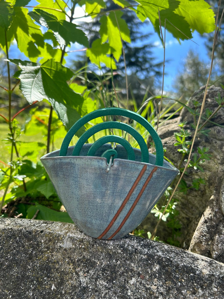Un pezzo appoggiato su un masso in mezzo al verde, con la spirale inserita.