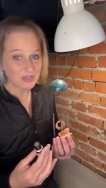 Mostrata dal vivo, appesa sotto una lampada davanti a un muro di mattoni.
