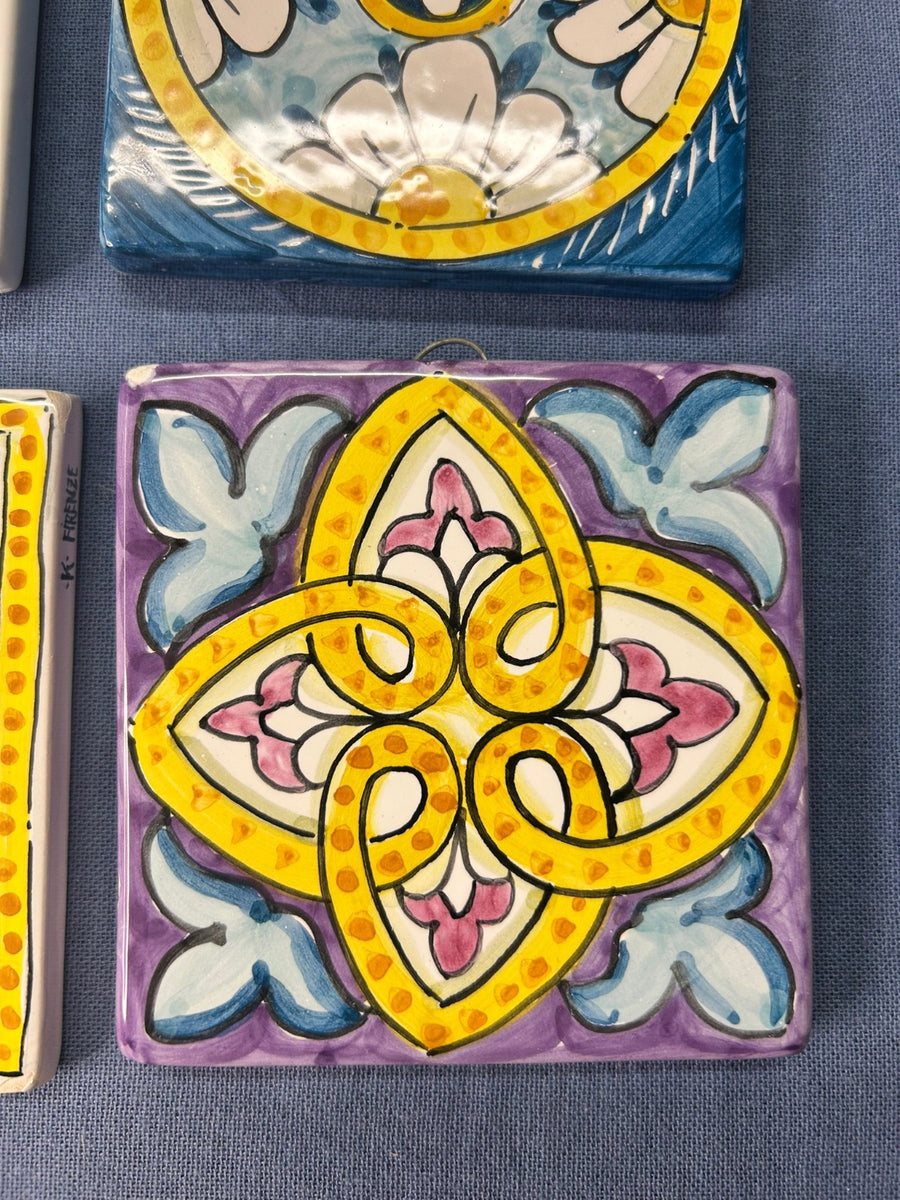 Mattonella con il decoro a quattro punte giallo e rosa su fondo lilla.