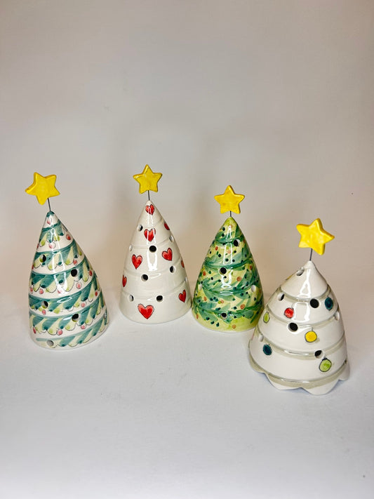 Quattro alberelli di ceramica con la stella gialla in cima, dipinti in verde e bianco.