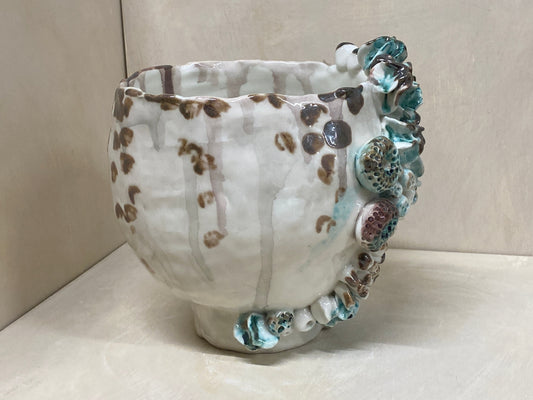 Vaso bianco con conchiglie modellate