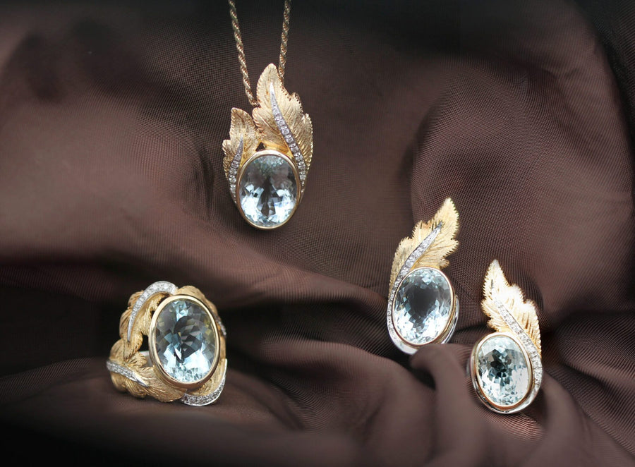 Overall shot of the parure on silk: pendant, ring and earrings with the same aquamarine and the same engraved leaves. The price on this page covers the ring only, the other pieces are not included