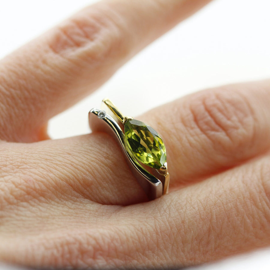 The ring on the finger: the peridot set crosswise and the diamond on the white band