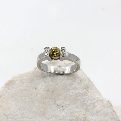 The yellow diamond seen from the front, between the two white gold crossbars