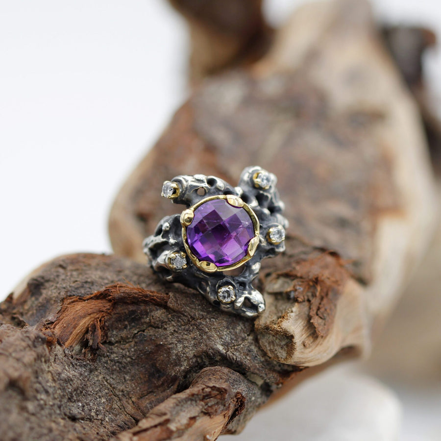 From above, on the wood: the irregular openings of the silver and the diamonds set without forming a ring.