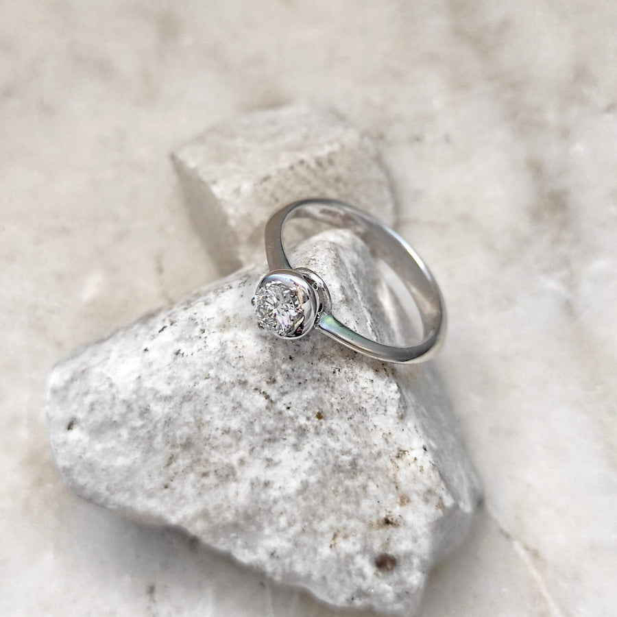 The ring lying on a stone: the bezel in close-up and the arc of the band