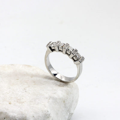 The ring standing on a white stone: the whole row, four large brilliants and five crossbars