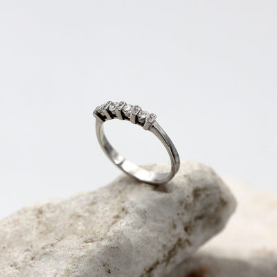 The ring standing on a stone: the low row of four brilliants between the five cross bars