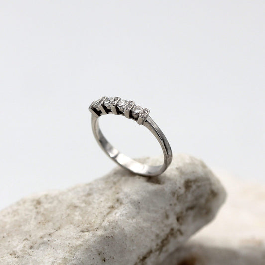 L'anello in piedi su una pietra: la fila bassa dei quattro brillanti fra le cinque traversine