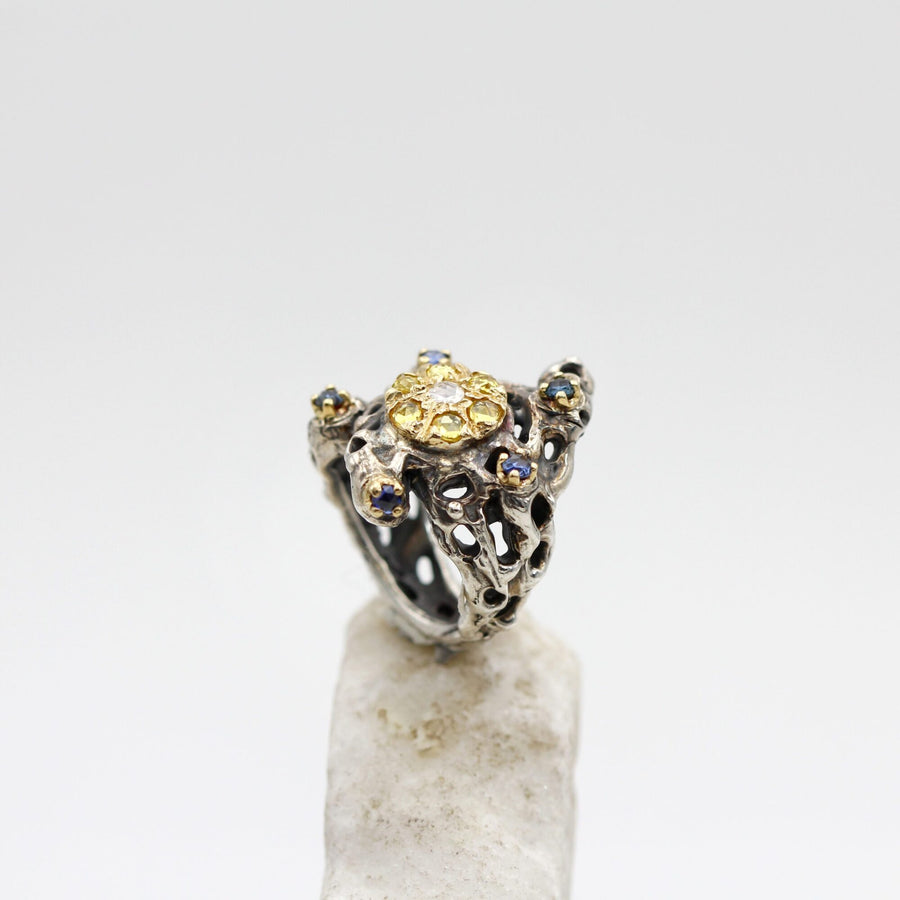 The band from the front: the craters of the silver and two blue sapphires on the shoulders