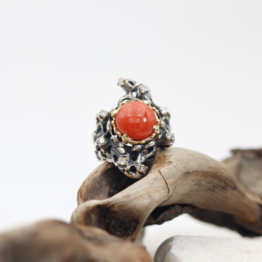 The ring resting on a piece of driftwood, three-quarter view
