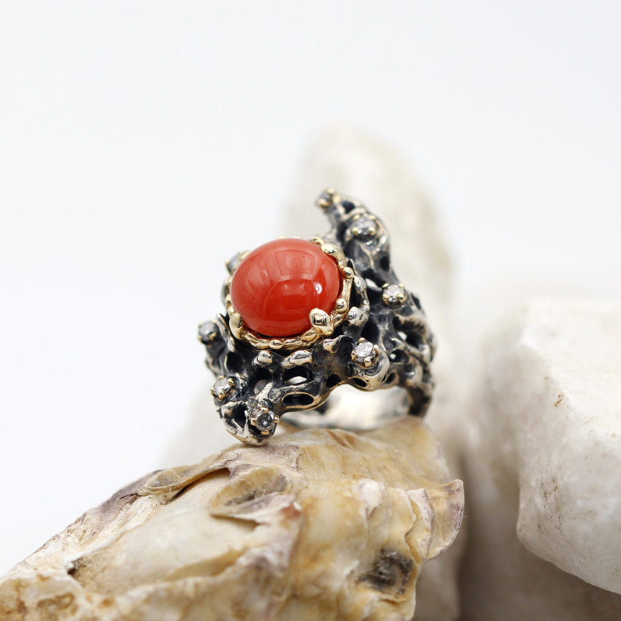 Three-quarter view on a light stone, with the silver band in view beneath the bezel