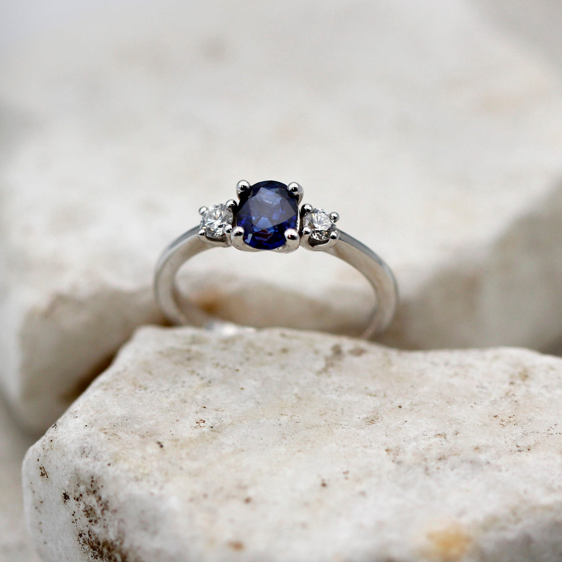 L'anello di fronte su una pietra chiara: lo zaffiro ovale al centro fra i due brillanti