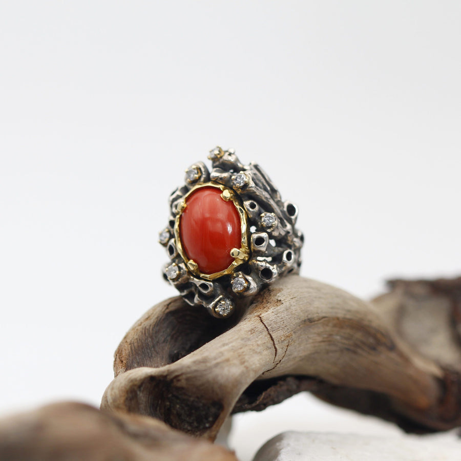 The ring resting on a piece of weathered wood, shot in three-quarter view