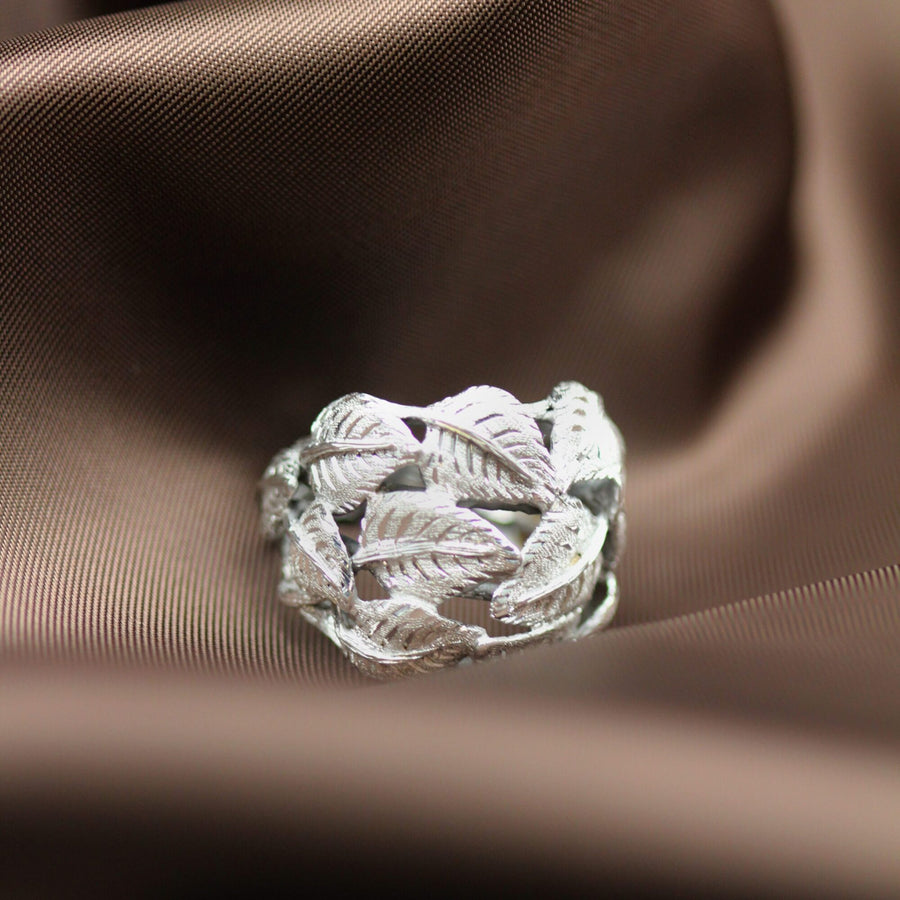The ring resting on dark satin, in grazing light