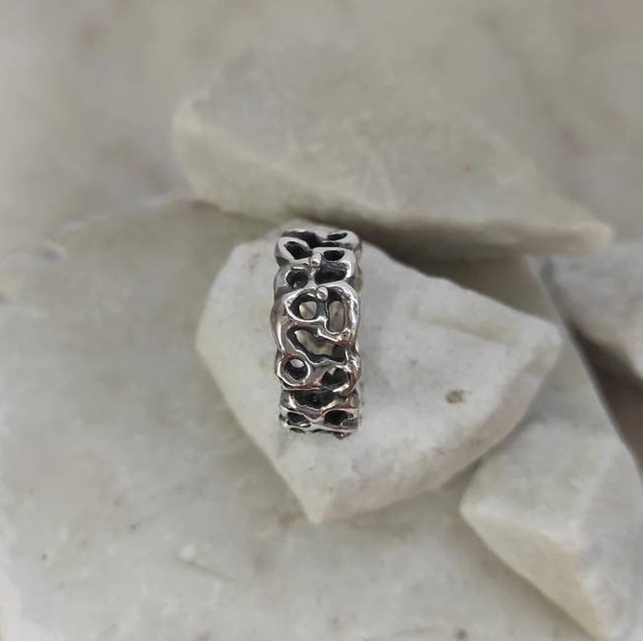 The ring upright among chips of light stone: the contained height of the band seen from the side.