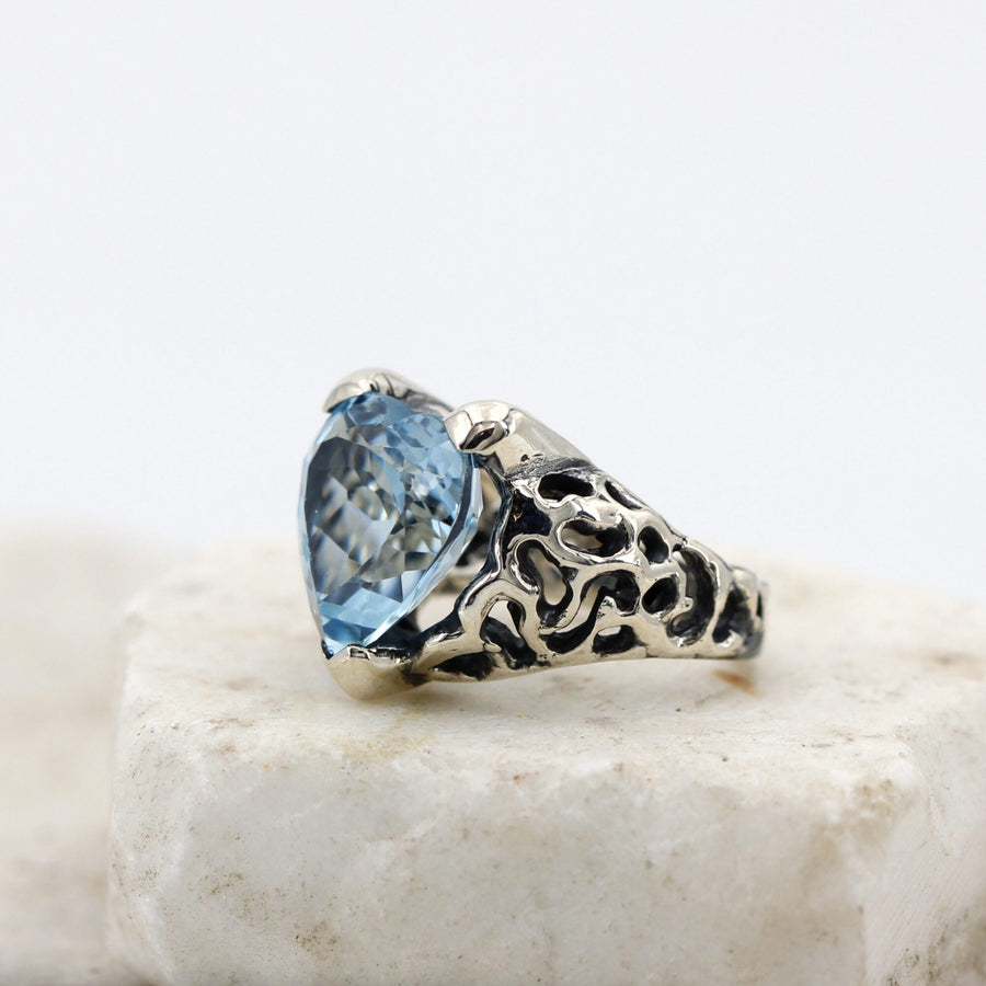 Side view: the openwork of the band and the faceted profile of the stone