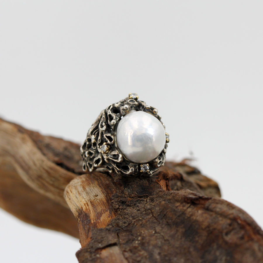I brillanti nei castoni d'oro, uno per ogni punto attorno alla perla