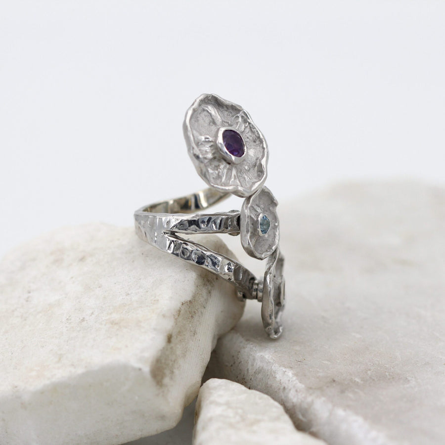 Side view: the hammered band that opens into two arms beneath the corollas