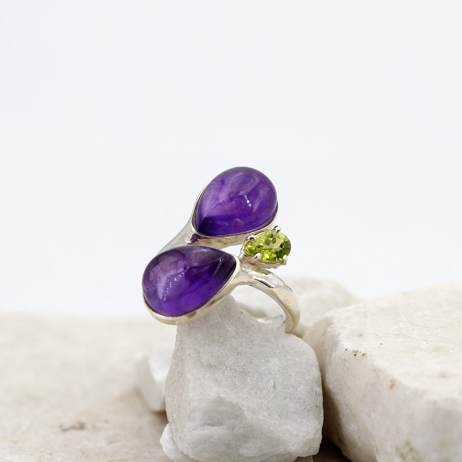 L'anello in piedi di fronte: le due ametiste affiancate e il peridoto sollevato sul suo collarino.