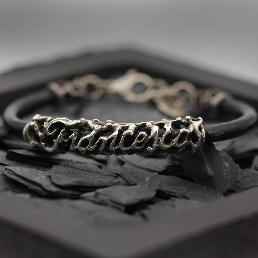 Il bracciale su ardesia nera, con la catenella di regolazione visibile dietro