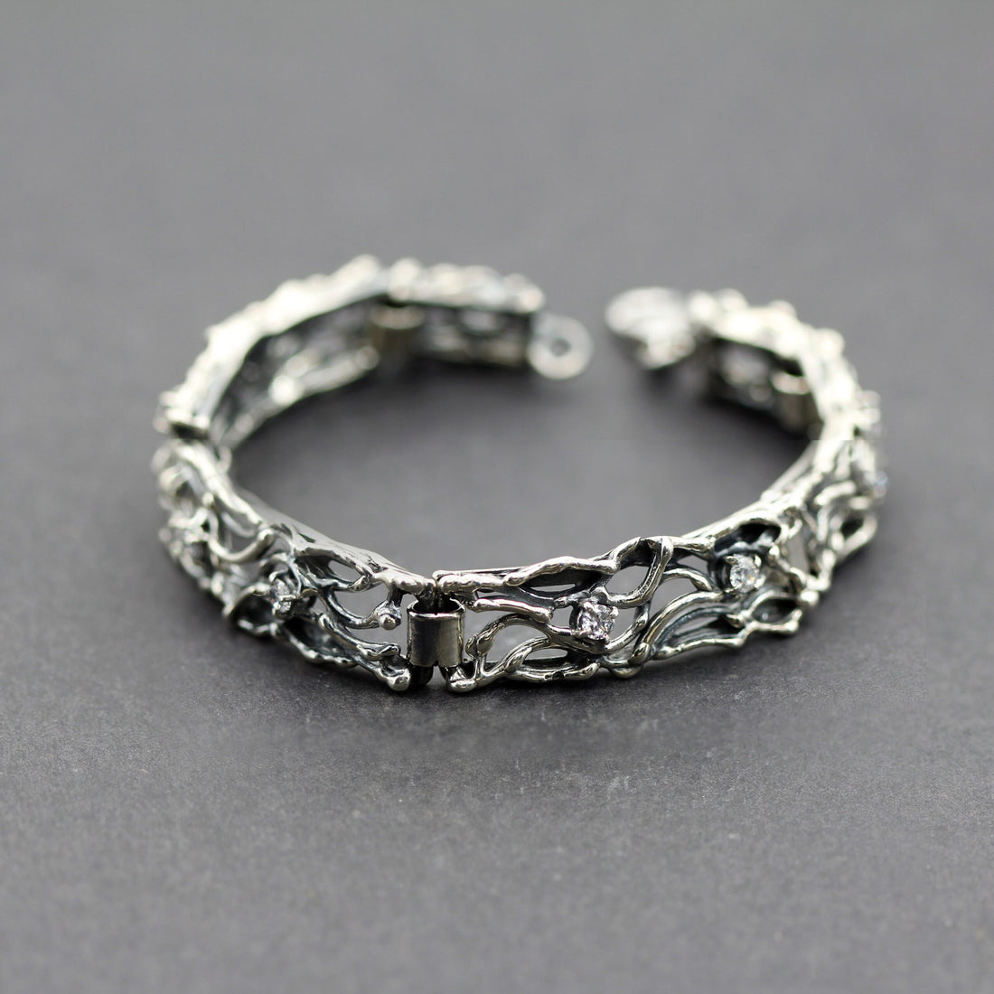 Il bracciale chiuso ad anello su fondo grigio, con il moschettone aperto in alto