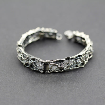 Il bracciale chiuso ad anello su fondo grigio, con il moschettone aperto in alto
