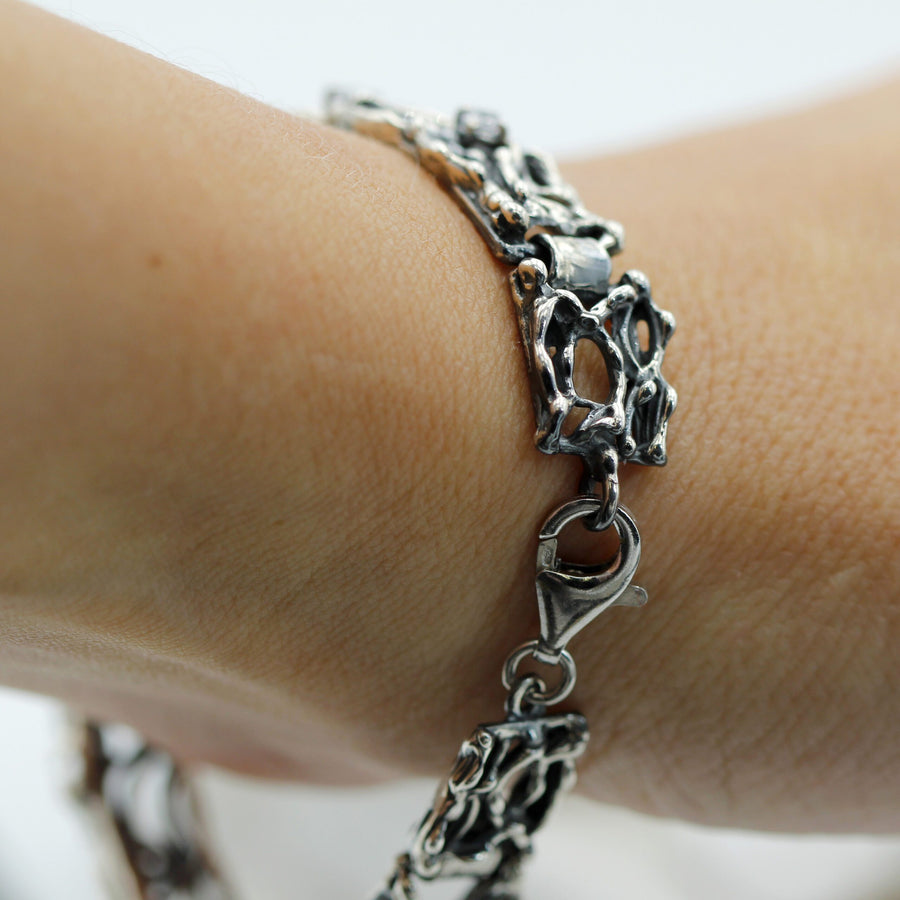 Il bracciale allacciato al polso, con il moschettone in vista